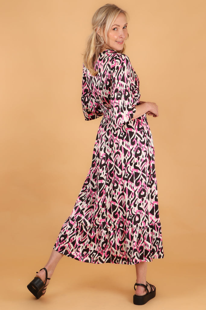 model showing the back of the dress with an all over pink ikat pattern