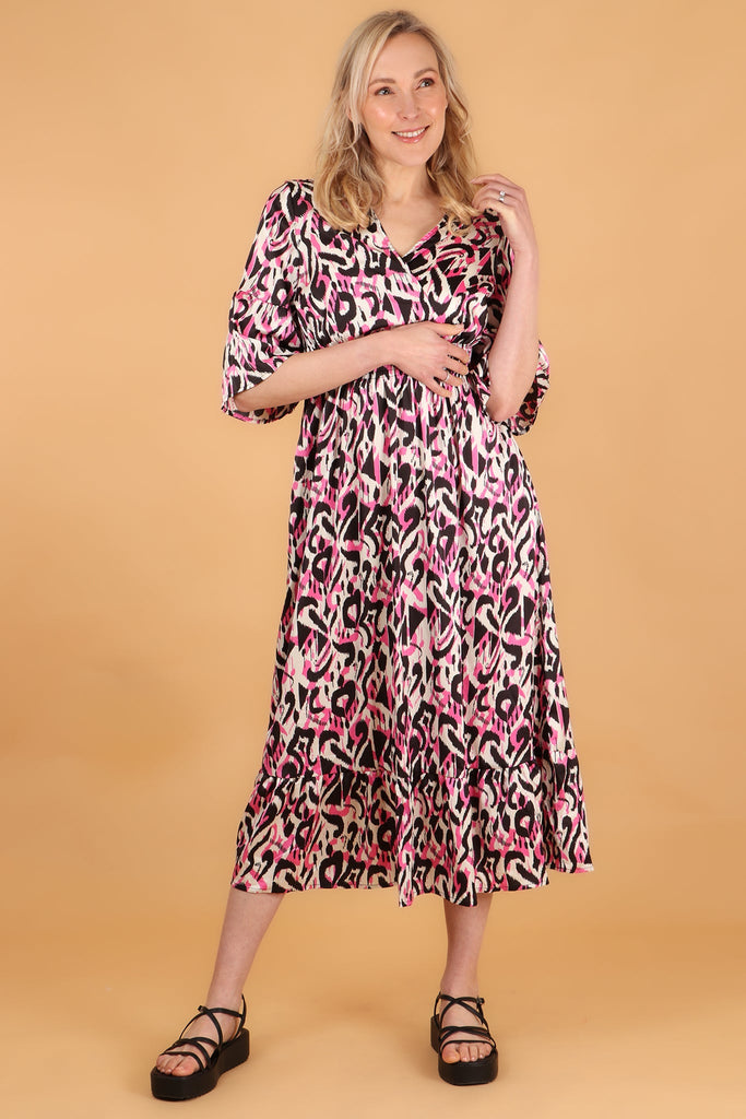model wearing a 3/4 shirred maxi dress with v neck and all over pink ikat pattern