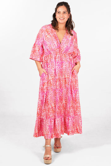 model wearing a pink painted chevron print v neck shirred maxi dress with 3/4 fluted sleeves
