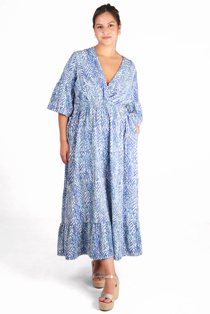 model showing that this blue shirred maxi dress has pockets