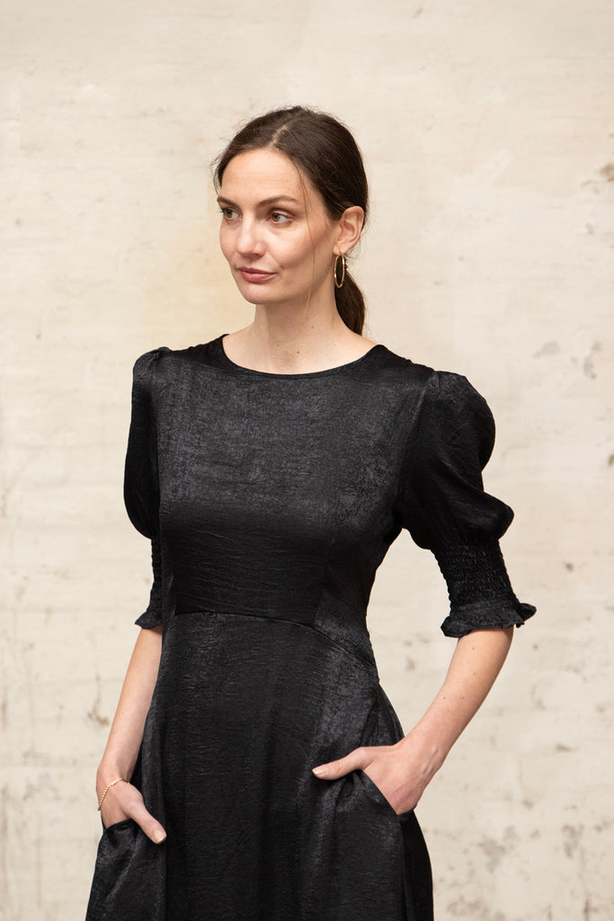 close up of the round neck and empire waist on the black tea dress