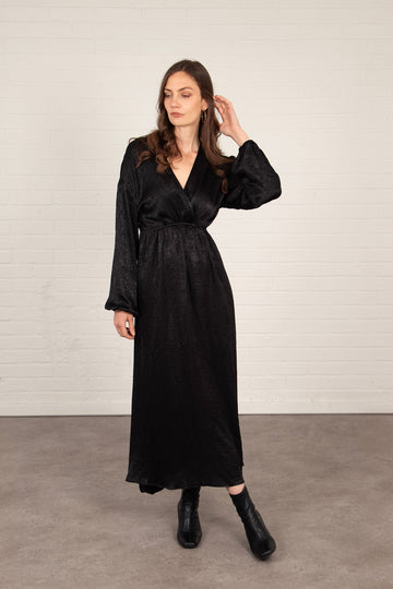 model wearing a long sleeve black maxi dress with a v-neck and faux wrap top