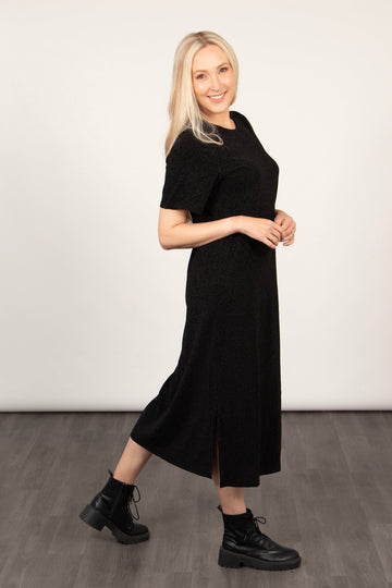 model wearing a sparkly black midi t-shirt dress with short sleeves and a side split, the dress has a round neck and is loose fitting