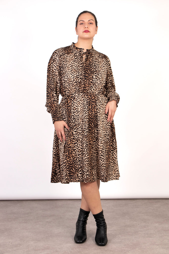 model wearing a knee length leopard print skater dress with long sleeves and a grandad style collar