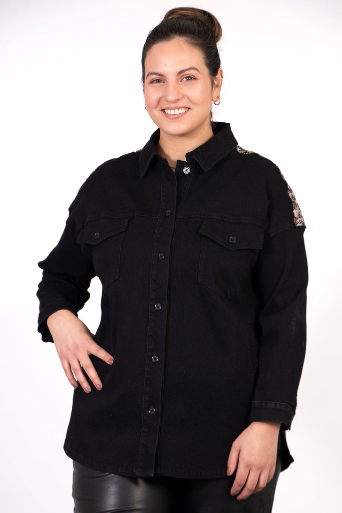 model showing the front of the shacket which is plain black, the leopard print panel on the back is slightly visible on the side of the shoulder