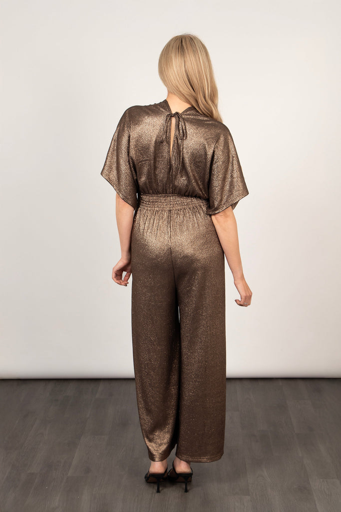 model showing the back of the jumpsuit, showing the tie at the back of the neck and elasticated waist.