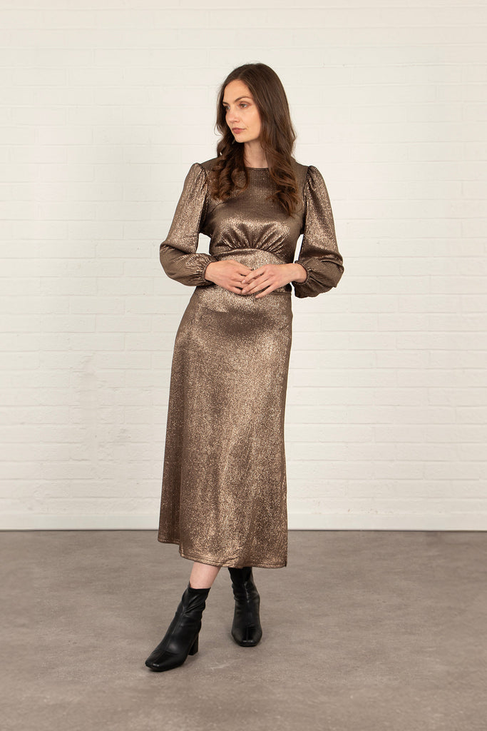model wearing a long sleeve midi tea dress with an all over bronze glitter sparkle