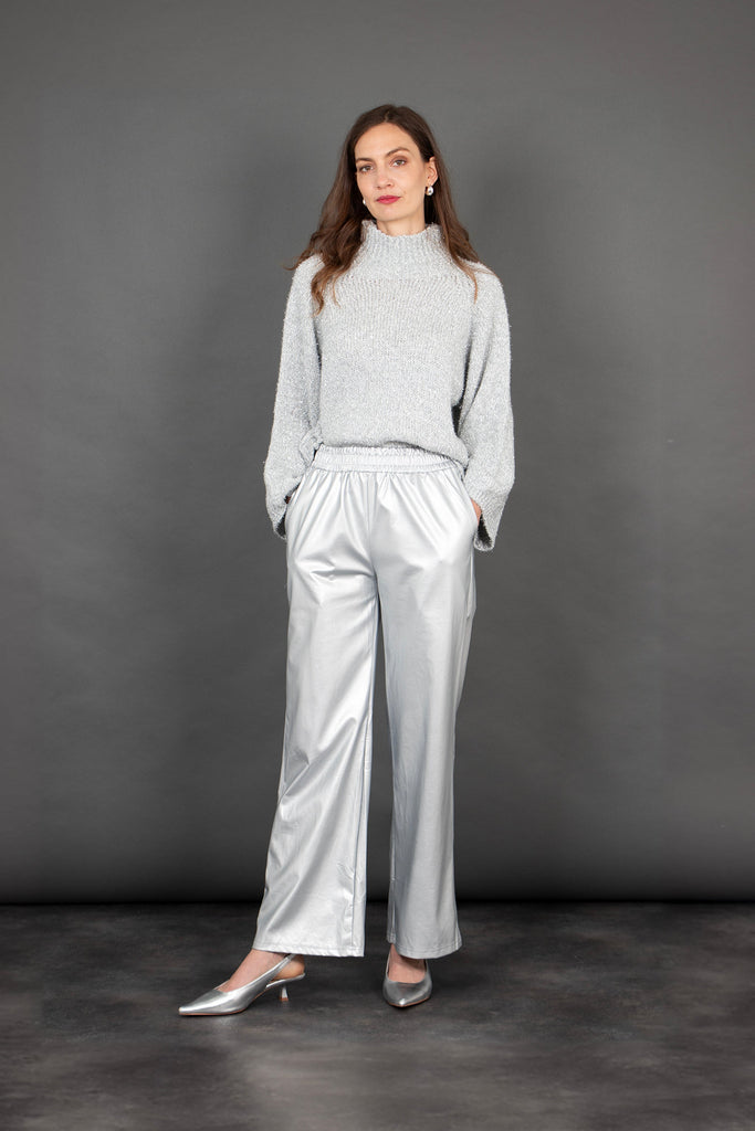 model wearing long silver faux leather trousers with a silver sparkly jumper