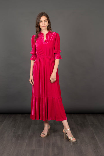 model wearing a raspberry pink tiered midaxi dress with 3/4 fluted sleeves and an open v-neck