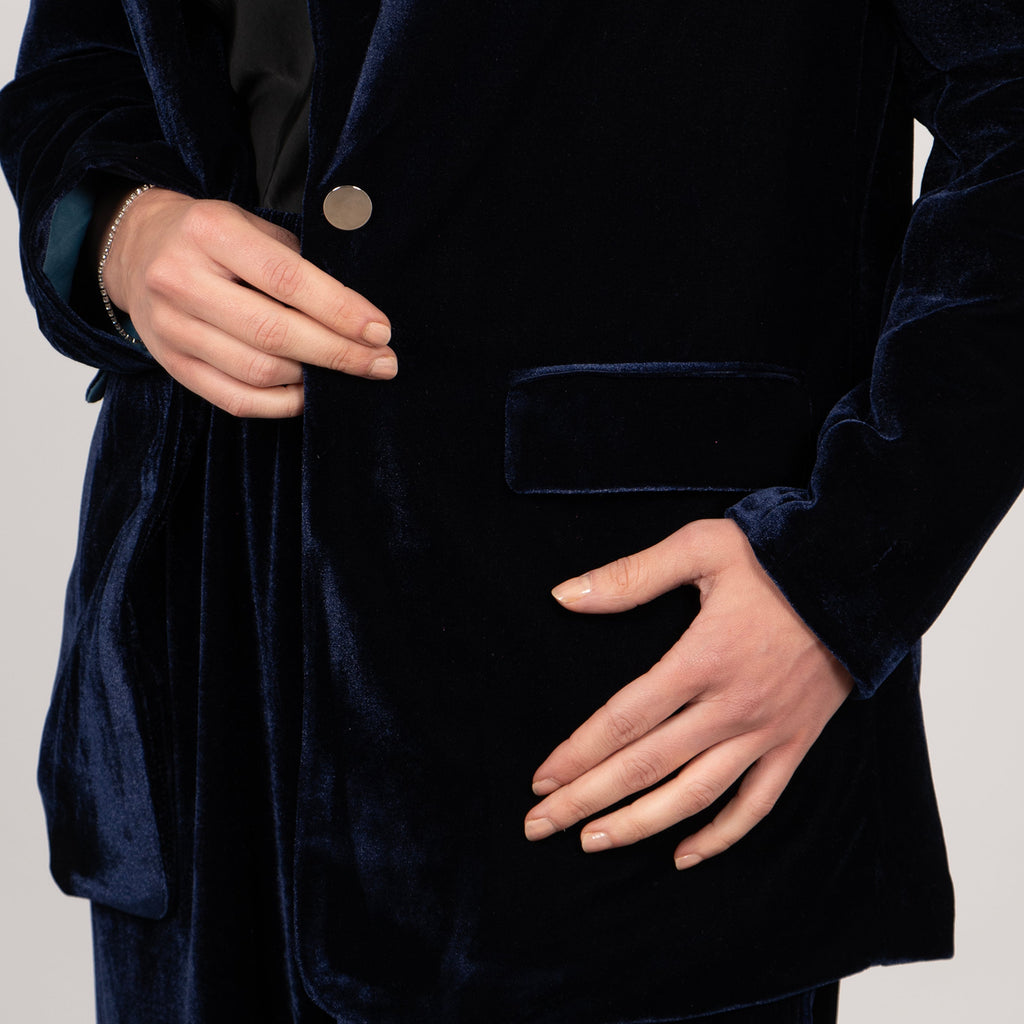 close up of the front button and side pockets on the navy blue velvet jacket