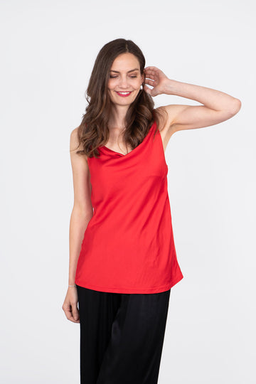 model wearing a crimson red camisole top with a cowl neck and spaghetti straps