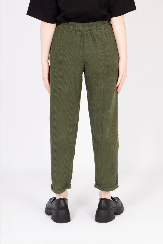 model showing the back of the khaki babycord trousers, the tapered leg feature is visible