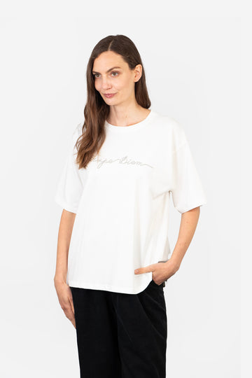 model wearing a white cotton t-shirt with the words, carpe diem, embroidered in silver on the front