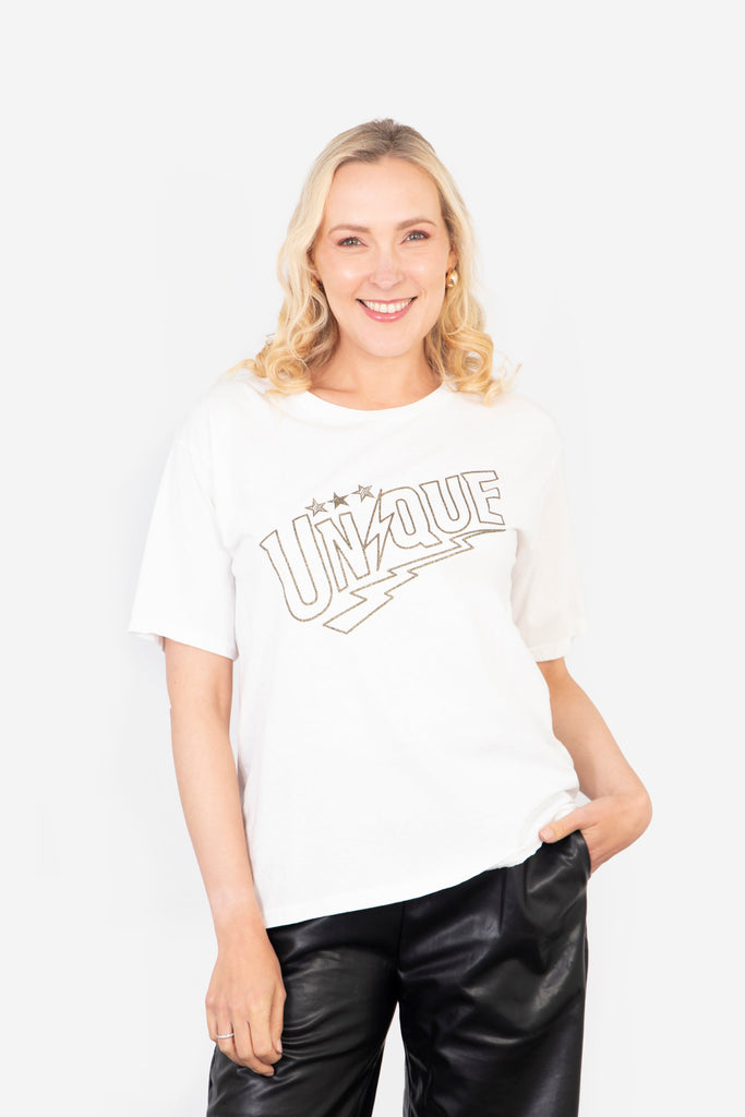 model wearing white t-shirt with a gold embellished glitter slogan "unique" on the front