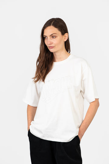 model wearing a relaxed fitting glitter t-shirt in white. the shirt has short sleeves and a round neck