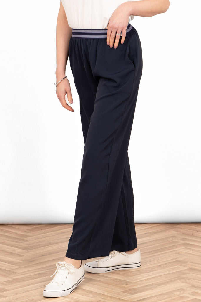 amber-wide-leg-trousers-navy-blue-model-showing-side-view-the-trousers-have-side-pockets