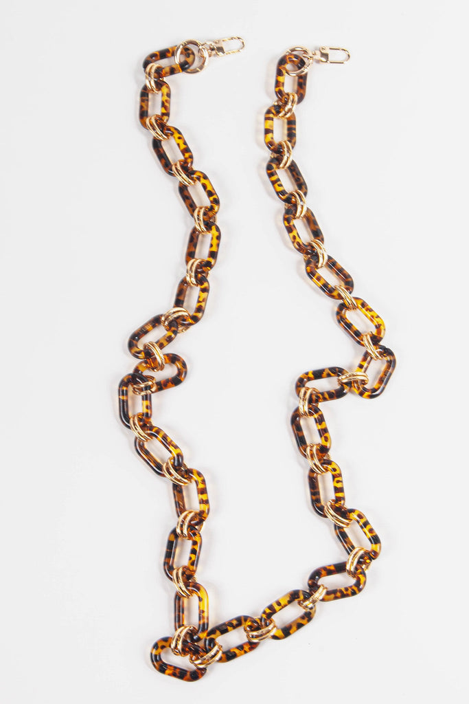 close up of the brown tortoise shell patterned bag strap