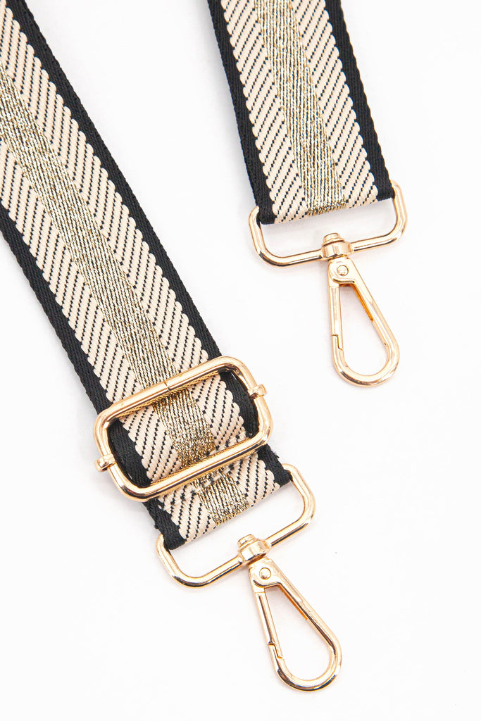 close up of the gold clip on snap hook and adjustable buckle on the bag strap