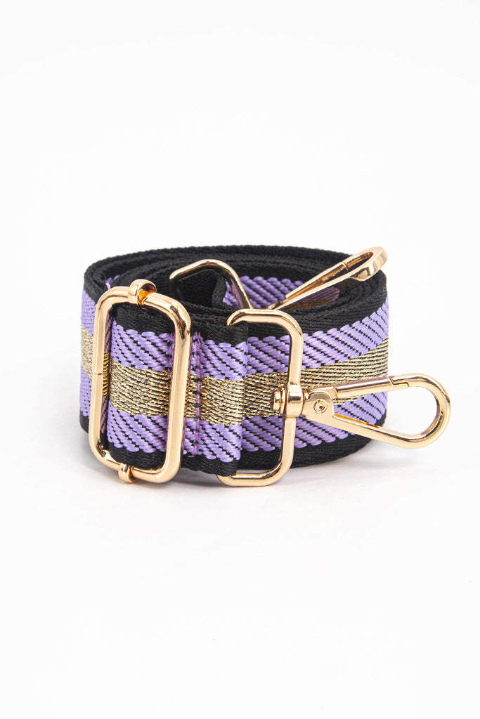 showing the bag strap coiled around itself, the lilac and gold glitter stripe pattern woven design is prominent , the gold hardware is shown in close up