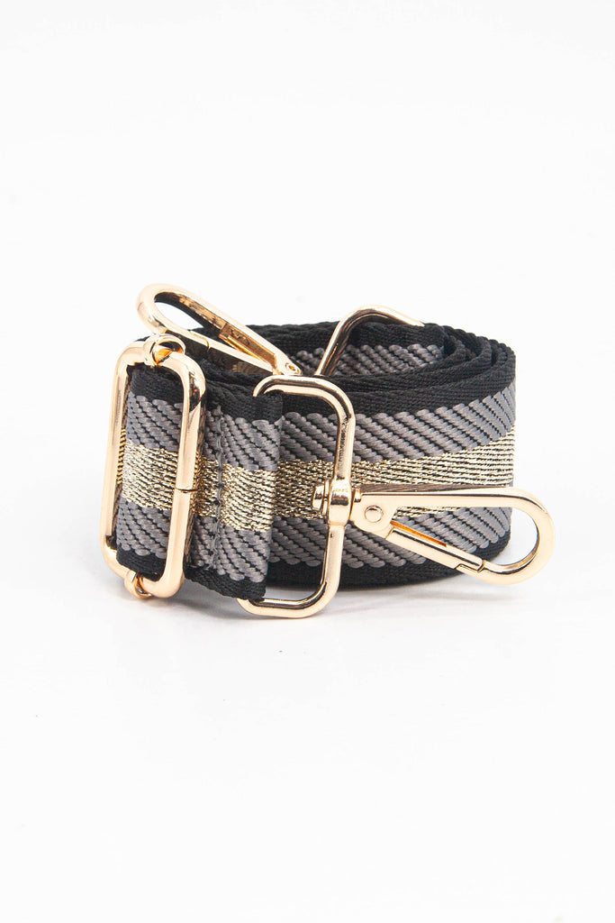 showing the bag strap coiled around itself, the grey and gold glitter stripe woven design is prominent , the gold hardware is shown in close up