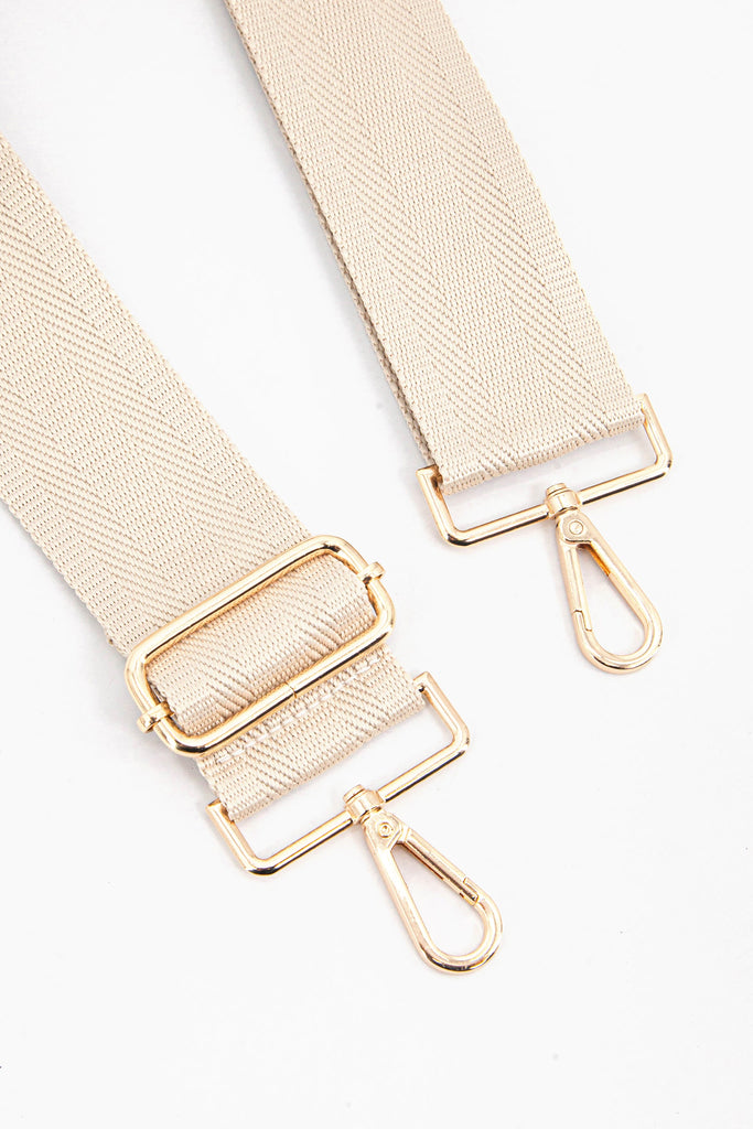 close up of the gold clip on snap hook and adjustable buckle on the bag strap