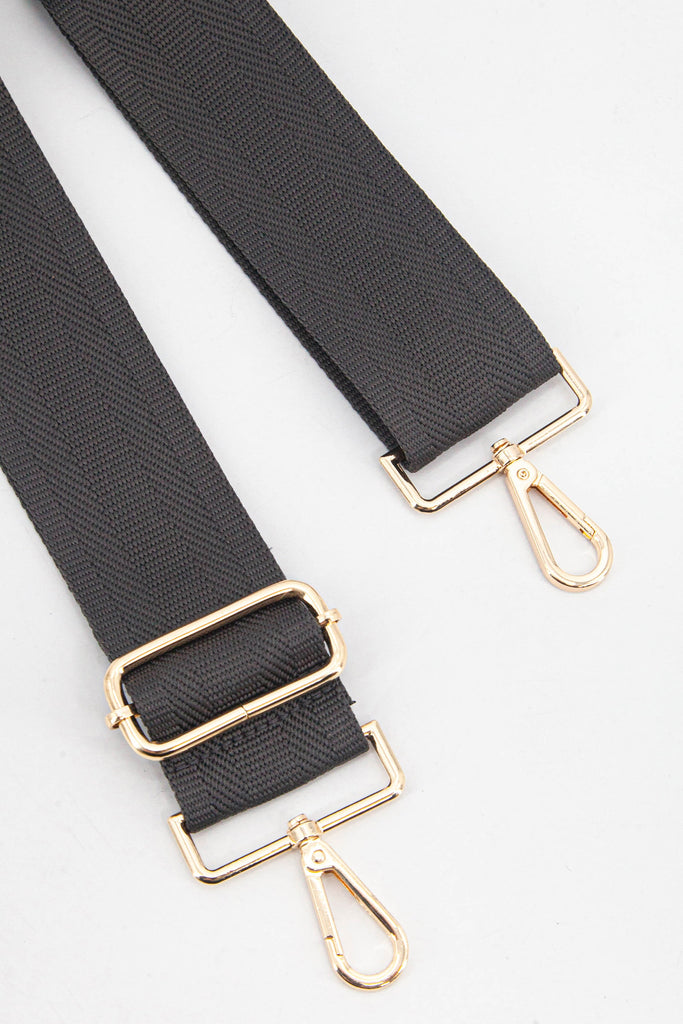 close up of the gold clip on snap hook and adjustable buckle on the bag strap