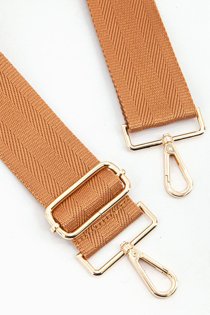 close up of the gold clip on snap hook and adjustable buckle on the bag strap