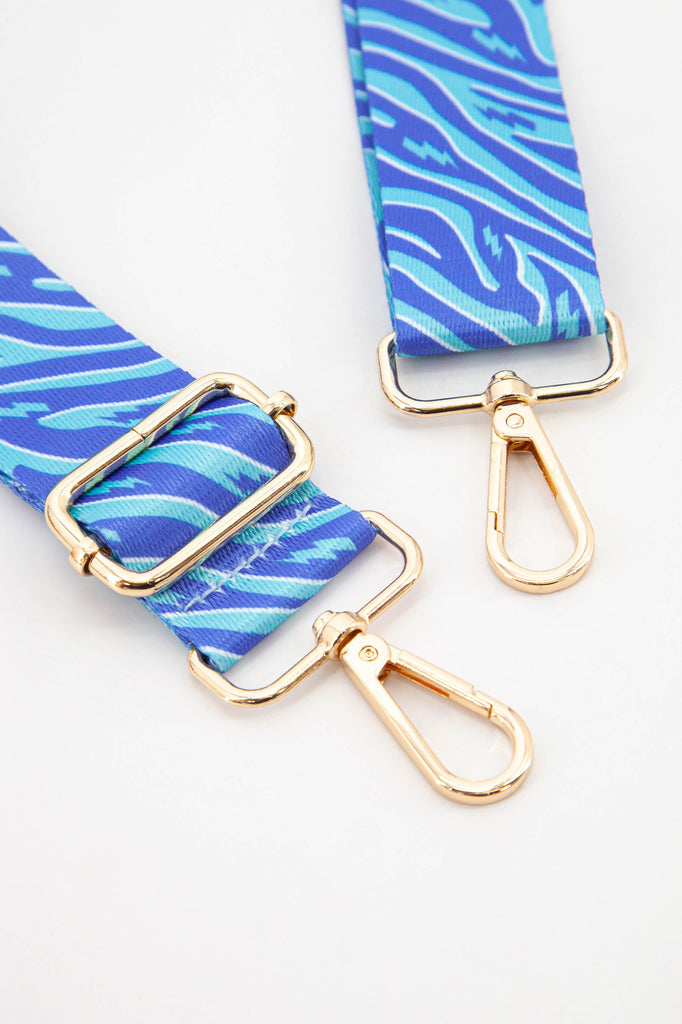 close up of the gold hardware, clip on snap hooks which can be used to attach the bag strap to any bag