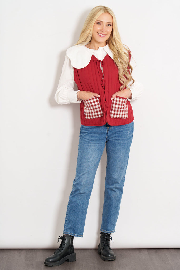 tabby-quilted-reversible-gilet-red-cream-gingham-model-hands-front-pockets
