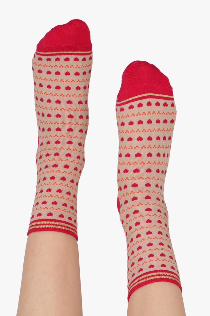 Ladies feet straight in the air. All over heart and dot print can be seen along with contrasting pink toe detail