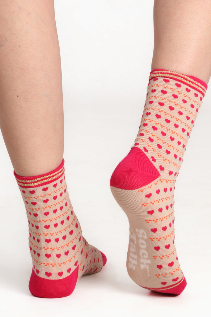 Ladies feet facing away from camera to show sole of sock. Highlighting the sock talk logo on sole and contrasting pink heel