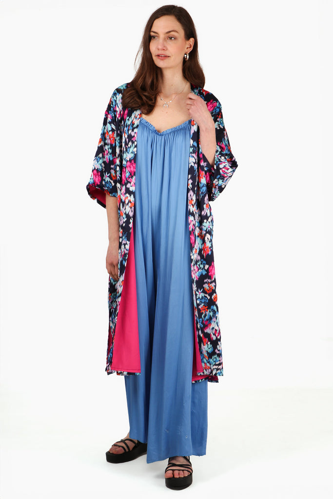 model wearing a mutlicolorued floral print kimono jacket with pink lining, the floral print is navy blue, white, red and pink 2