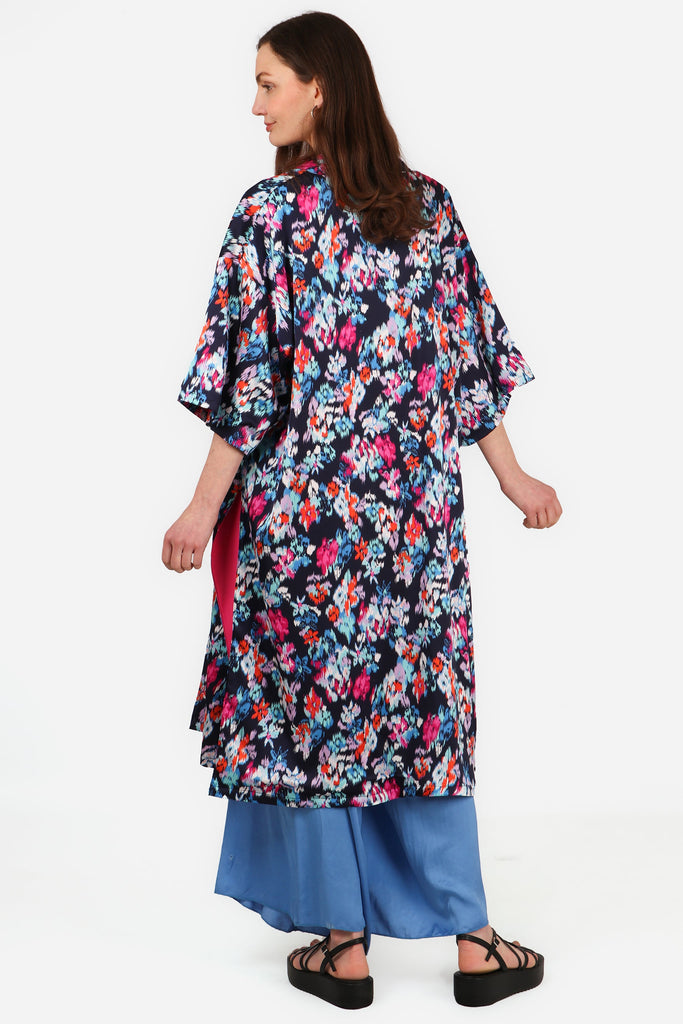 model wearing a mutlicolorued floral print kimono jacket with pink lining, the floral print is navy blue, white, red and pink 3
