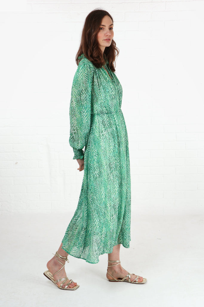 model wearing a green chiffon chevron print midi dress with long sleeves