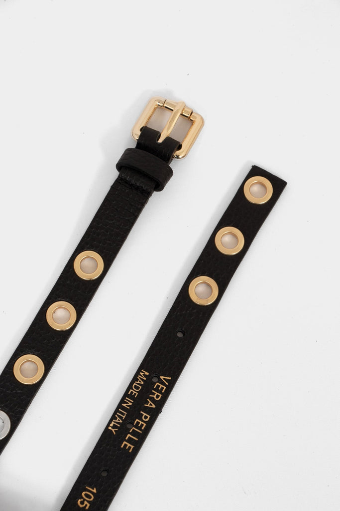a skinny black belt with gold coloured porthole fasternings and a gold buckle. the belt is made from pebbled italian leather.
