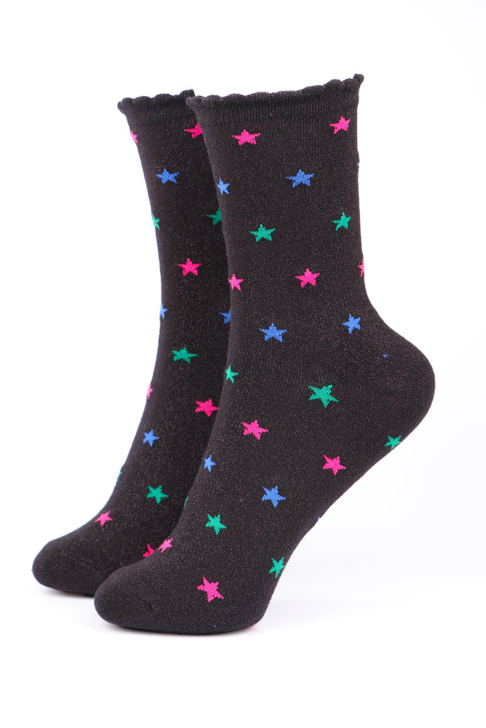 black socks with a scalloped cuff and a green, blue and pink star pattern with an all over glitter sparkle
