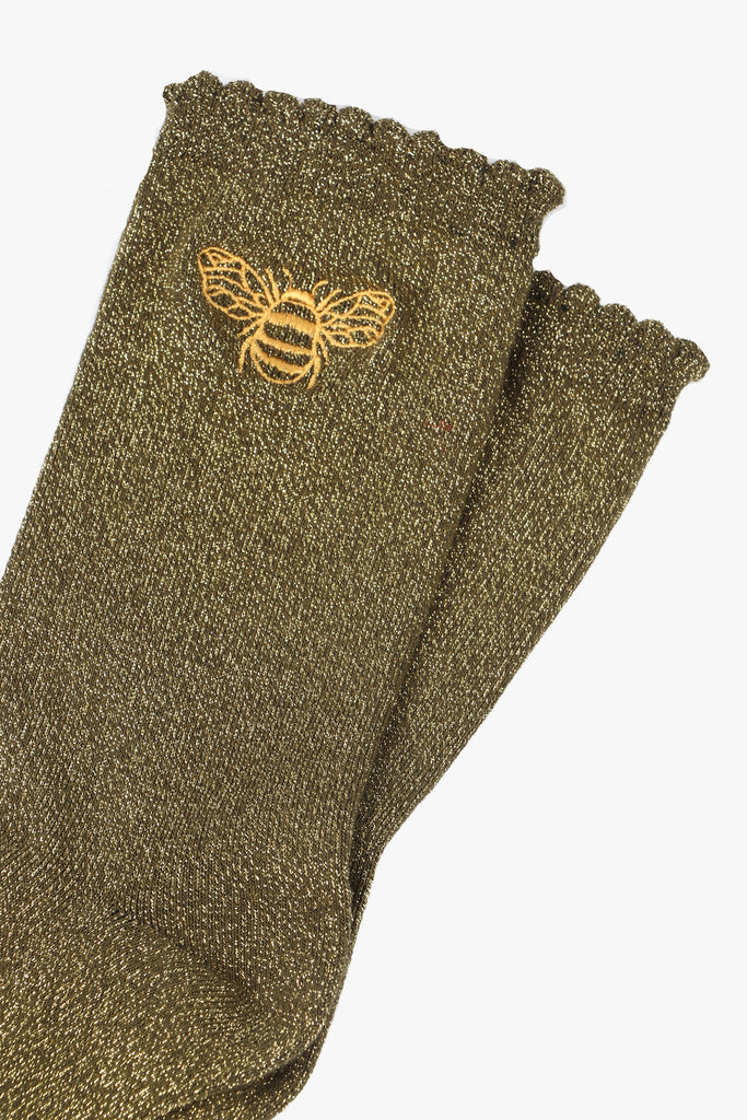 close up of the sparkly socks and embroidered gold bee