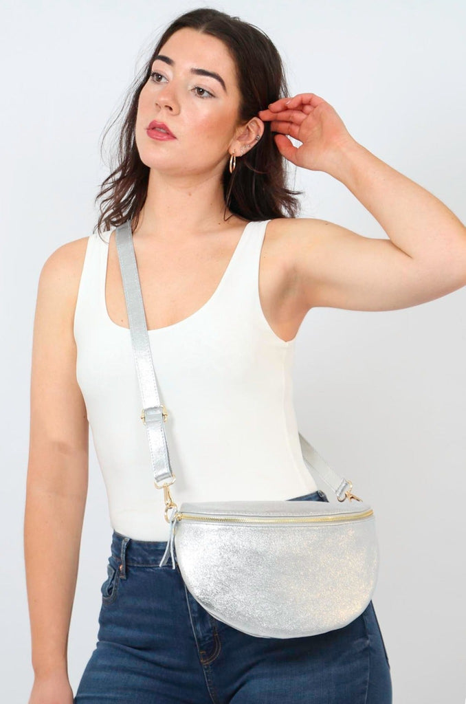 model wearing a large silver metallic leather crossbody bag 