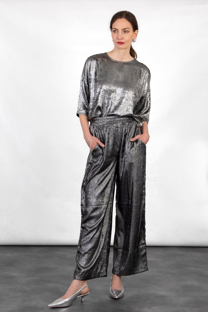 model wearing a metallic silver relaxed fitting box top, the top had a round neck and 3/4 sleeves