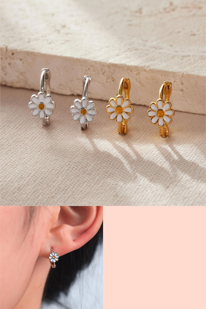 silver and gold sterling silver hoop earrings, each featuring a single white and yellow daisy flower on the rim of the hoops, the earrings are latch fastening