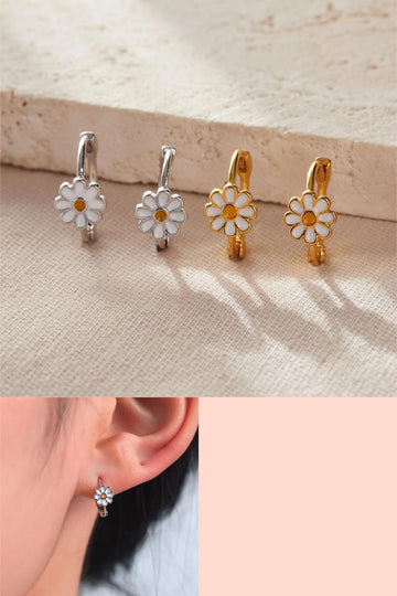silver and gold sterling silver hoop earrings, each featuring a single white and yellow daisy flower on the rim of the hoops, the earrings are latch fastening