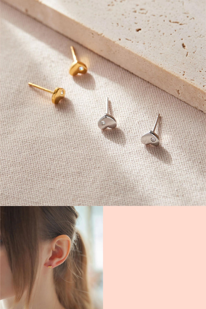 small love heart shaped stud earrings in silver and gold sterling silver, each love heart has a dainty single white cz crystal on one lobe of the love heart