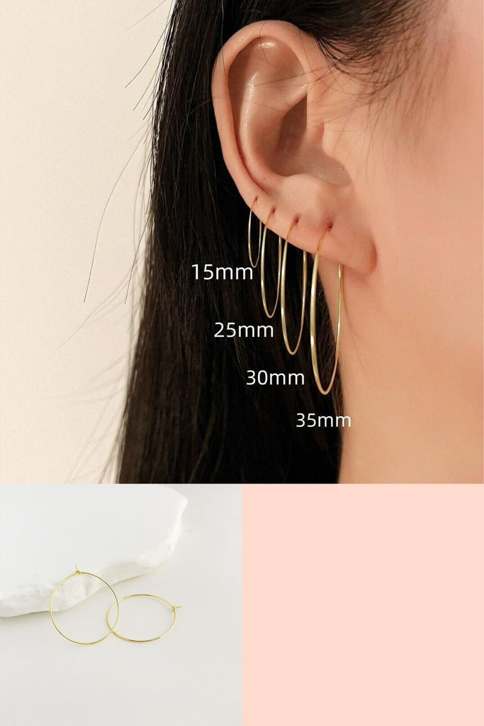 model wearing all four sizes of these thin gold plated sterling silver hoops, 15mm, 25mm, 30mm and 35mm hoop earrings with latch closure backings