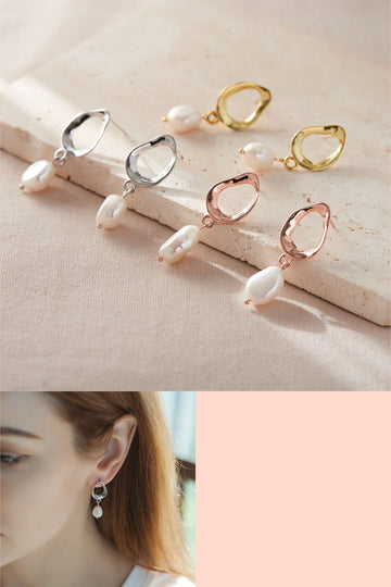 three pairs of sterling silver and natural pearl earrings, gold, silver and rose gold. each earring has a large uneven ring which attaches to the earlobe and a large pearl suspended below.