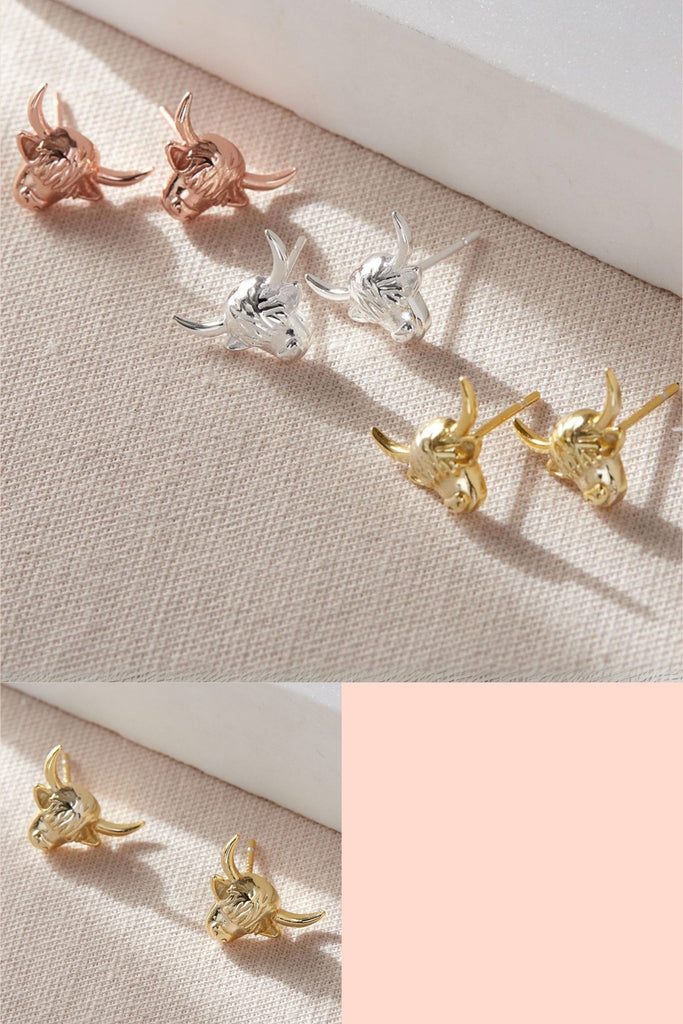 stud earrings in the shape of highland cow heads, in silver, gold and rose gold