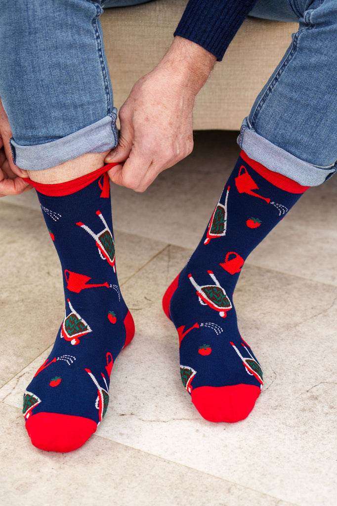 Person wearing navy socks with red and green patterns on a light background