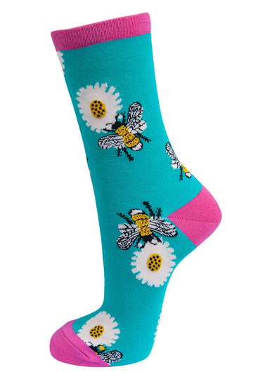 turquoise and fuchsia pink socks with a pattern of large bees and daisy flowers