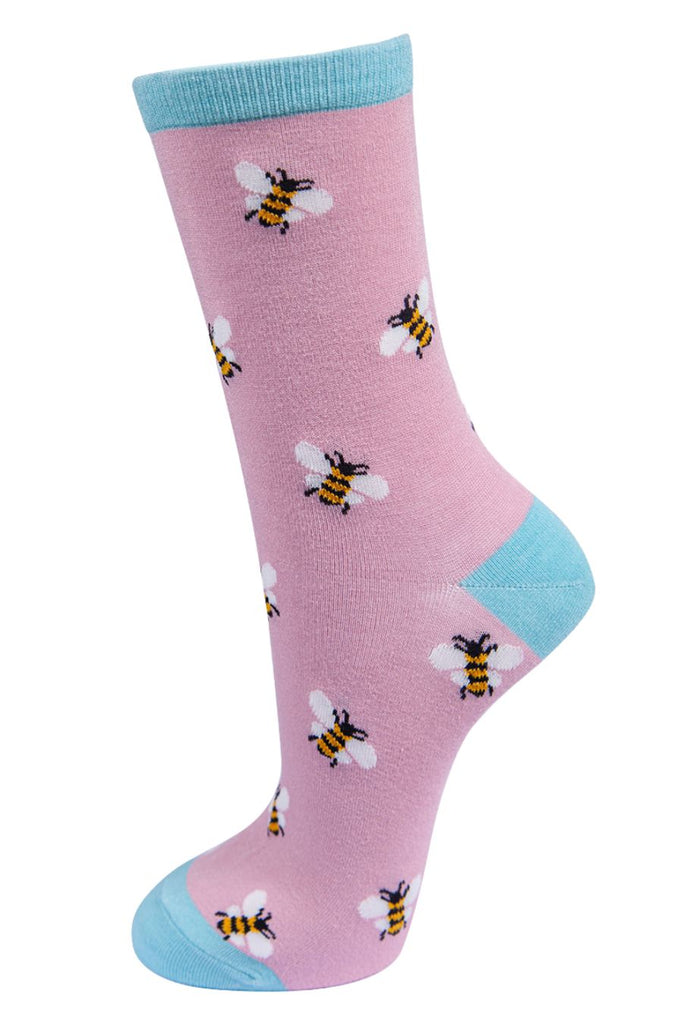 pink socks with pastel blue heel, toe and cuff with an all over pattern of yellow bumblebees