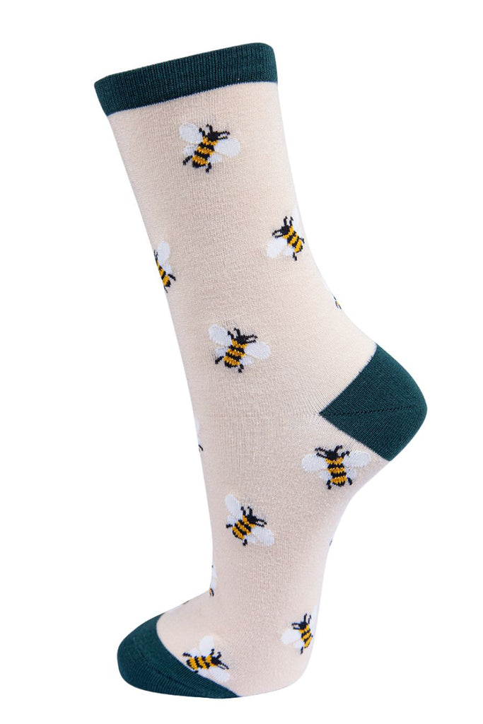 cream socks with a dark green heel, toe and cuff with an all over pattern of yellow bumblebees