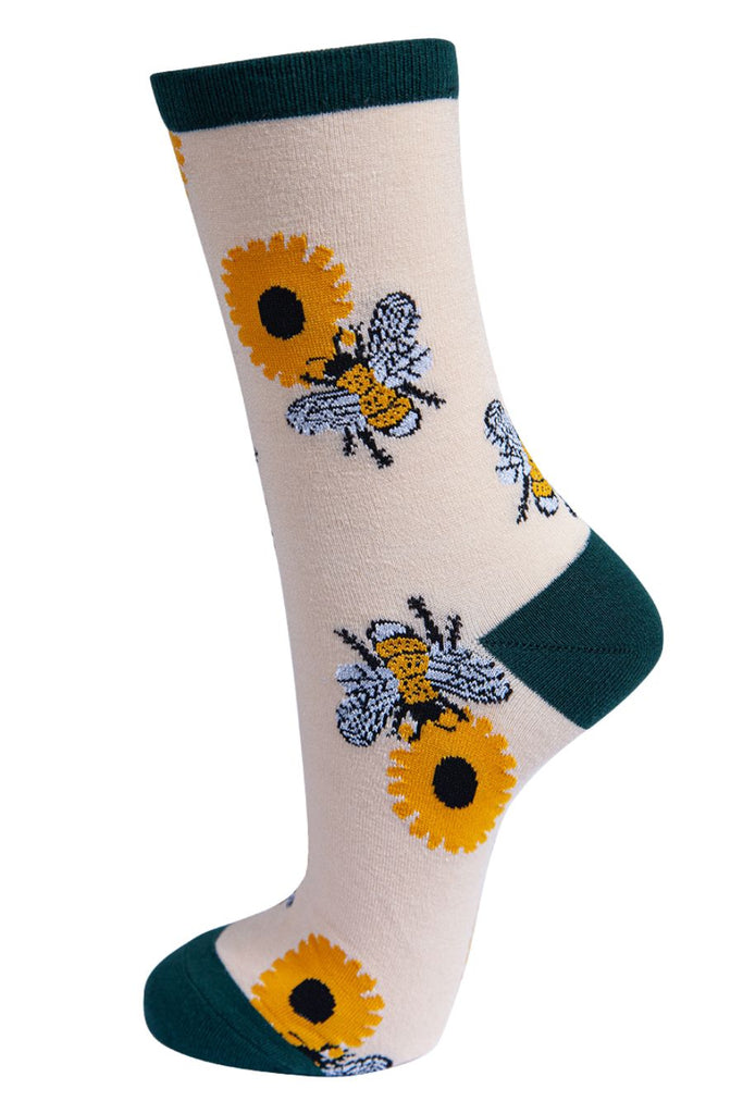 cream bamboo socks with green heel, toe and cuff with a bold pattern of bees and sunflowers